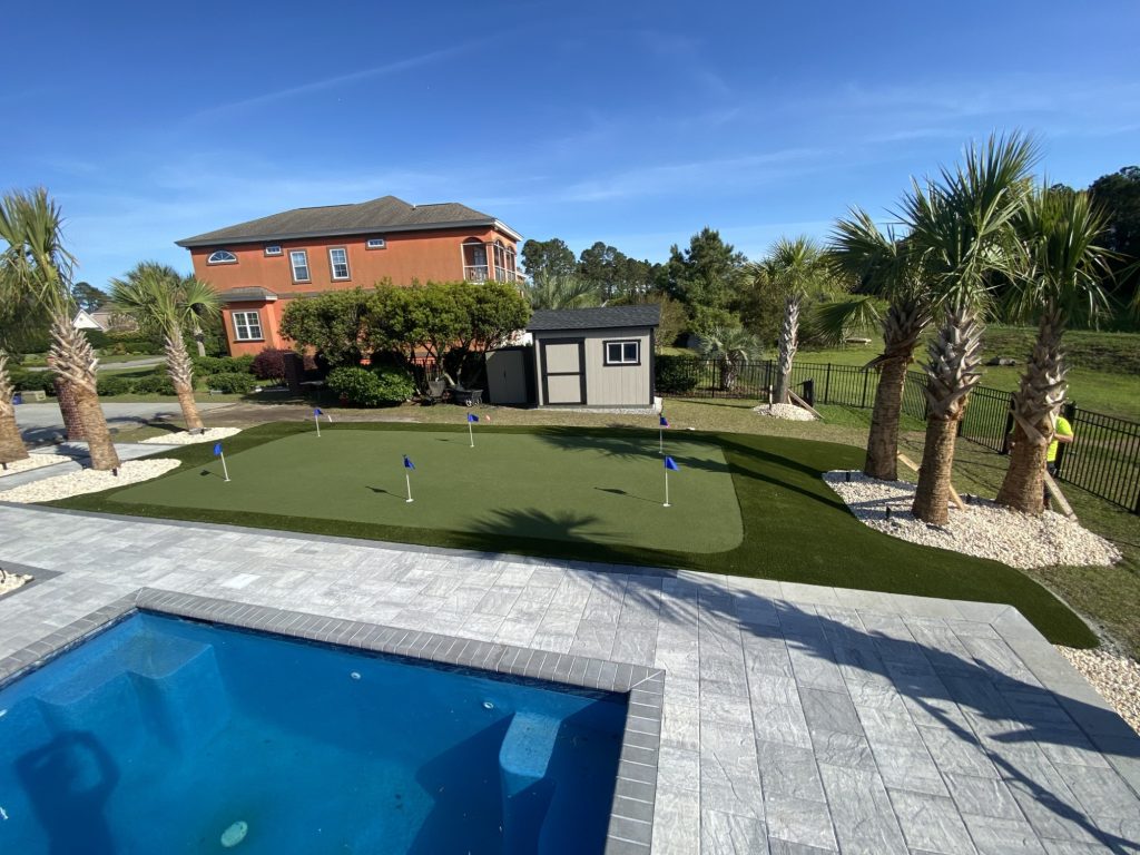Orange housed with artificial grass putting green by pool area