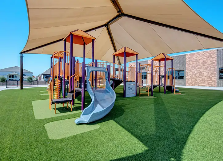 Blue slide and jungle gym artificial playground grass