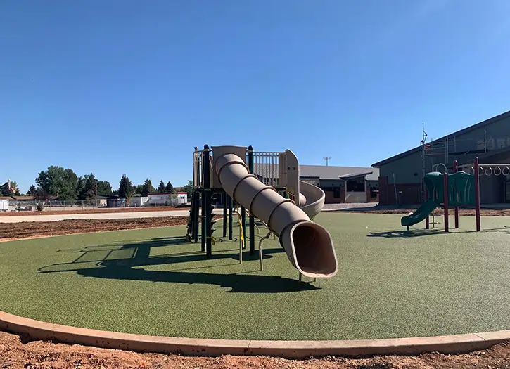 Slide installed on artificial playground grass