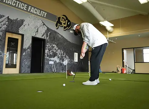 Golfer practicing with indoor putting green